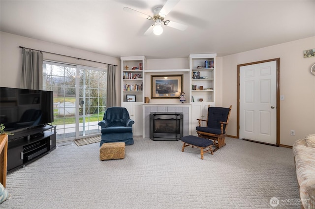 living room with a ceiling fan, light carpet, a fireplace, and baseboards