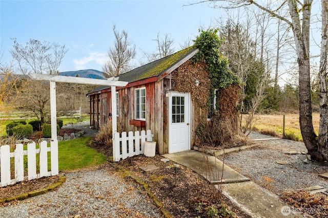 view of outbuilding featuring an outdoor structure, fence, and a mountain view