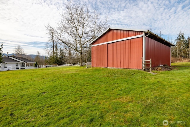 view of pole building featuring a lawn and fence