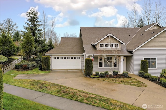 view of front of property with concrete driveway, a garage, and fence