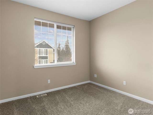 spare room with baseboards, visible vents, and carpet flooring