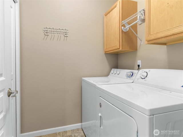 washroom featuring cabinet space, washer and clothes dryer, and baseboards