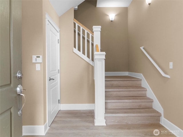 stairway with wood finished floors and baseboards