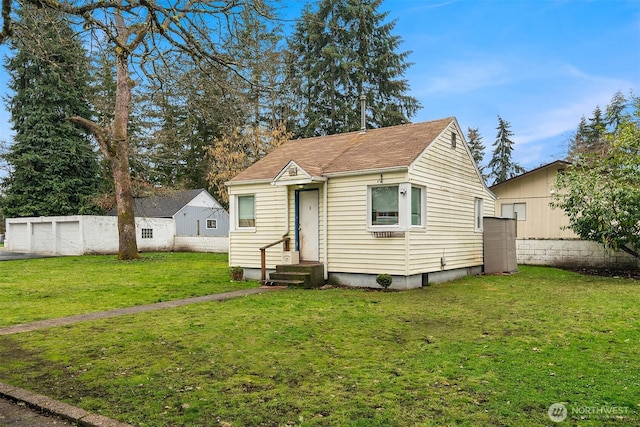 bungalow featuring a garage, entry steps, and a front yard