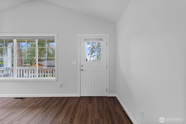 foyer featuring dark wood-style floors, lofted ceiling, visible vents, and baseboards