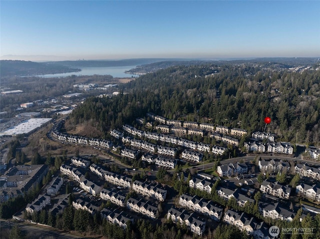 birds eye view of property featuring a water view and a wooded view