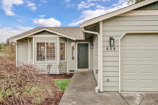 property entrance featuring a garage and roof with shingles