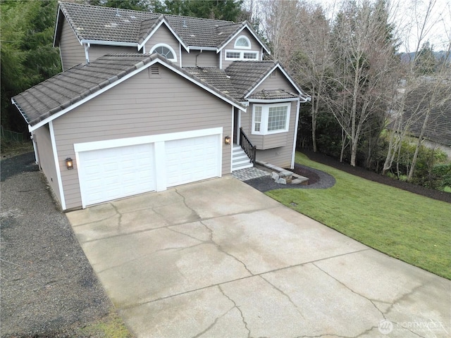 view of front of property featuring a front yard, concrete driveway, and a tiled roof