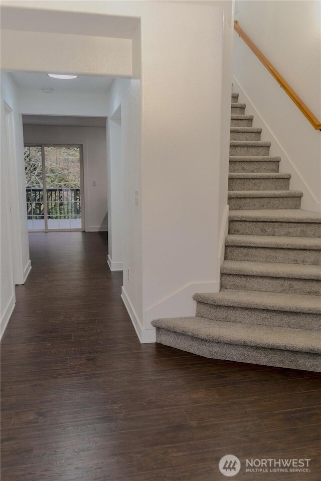 stairway featuring baseboards and wood finished floors