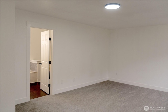 unfurnished room featuring carpet and baseboards