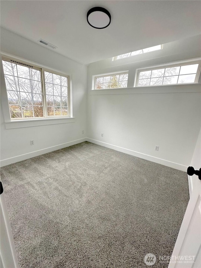 carpeted empty room with baseboards and visible vents