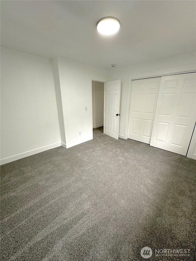 unfurnished bedroom featuring carpet, baseboards, and a closet