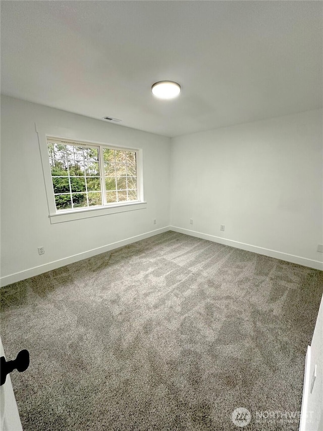 carpeted empty room with visible vents and baseboards