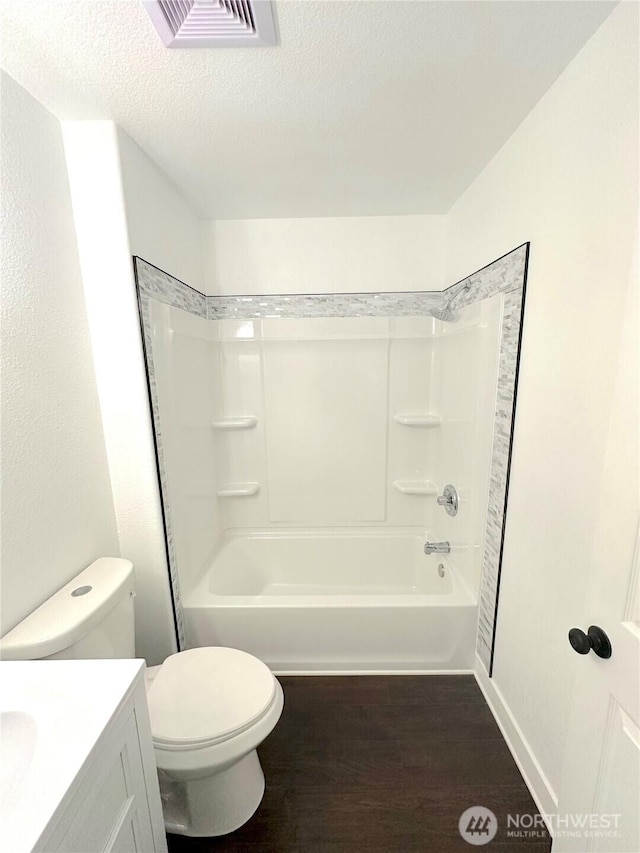 bathroom with visible vents, toilet, wood finished floors, a textured ceiling, and vanity