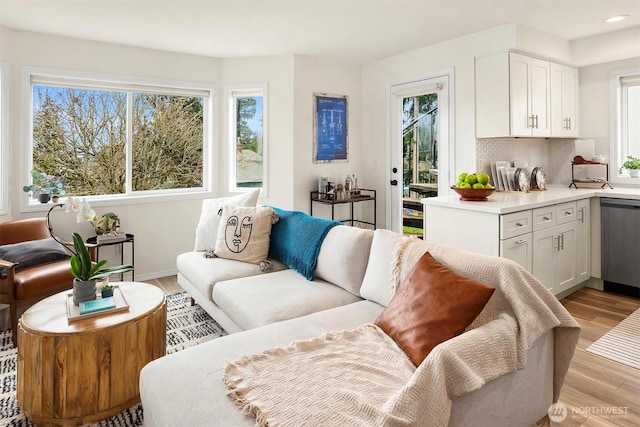 living room with recessed lighting, baseboards, and light wood finished floors