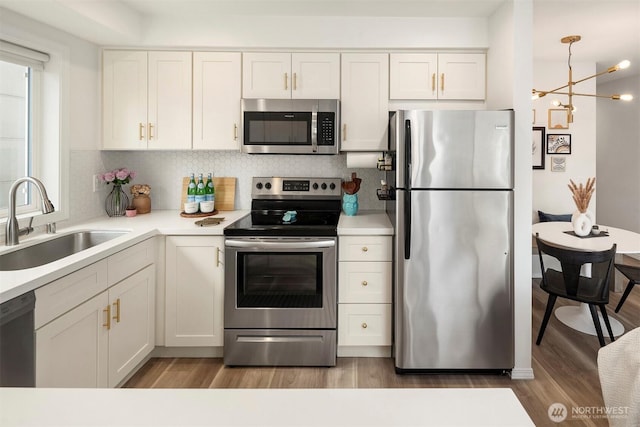 kitchen featuring stainless steel appliances, white cabinetry, a sink, and light wood finished floors