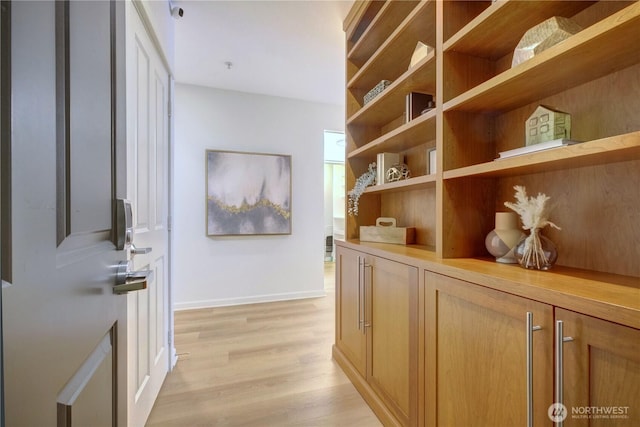 hallway featuring baseboards and light wood-style floors