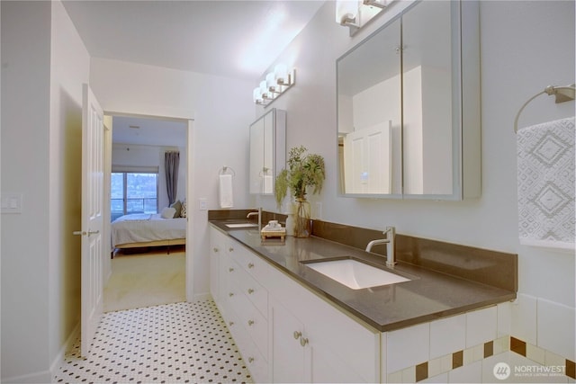 bathroom featuring double vanity, a sink, and ensuite bathroom