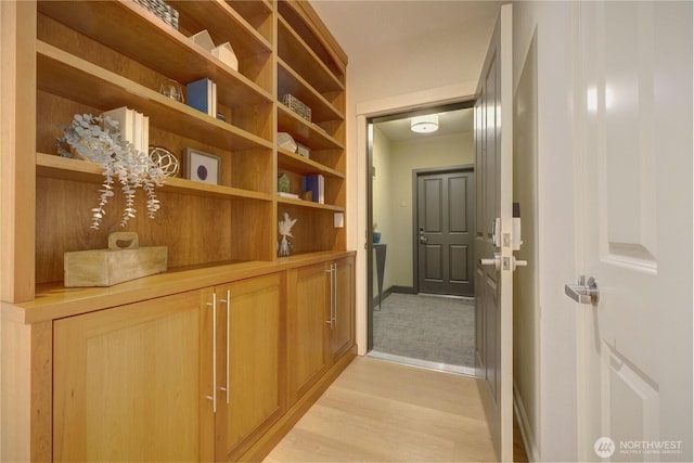 corridor with baseboards and light wood-style floors