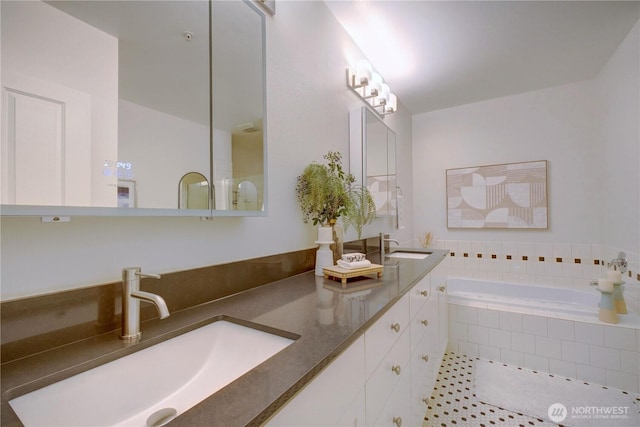 full bathroom with tiled tub, tile patterned flooring, a sink, and double vanity