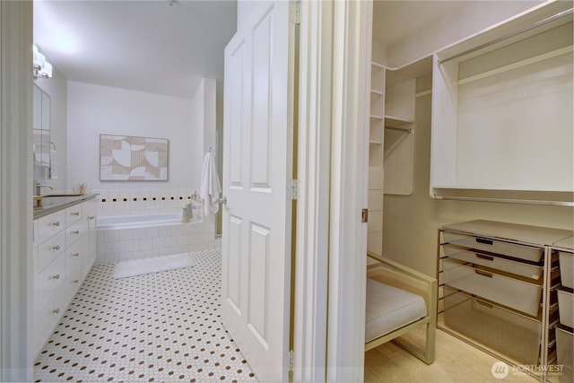 full bathroom featuring a garden tub, vanity, and tile patterned floors