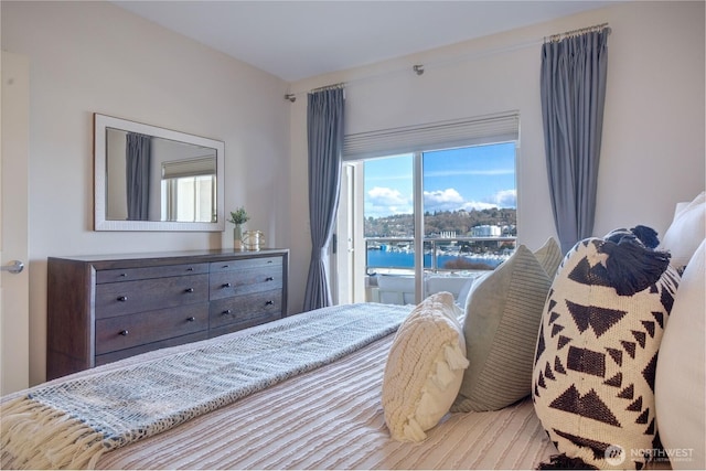 bedroom with access to outside and wood finished floors