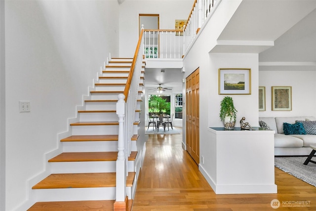 stairs featuring a high ceiling and wood finished floors