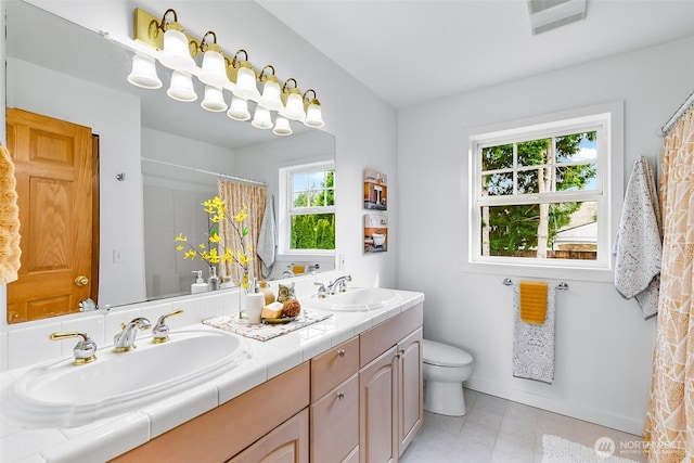 bathroom featuring double vanity, visible vents, a shower with curtain, and a sink