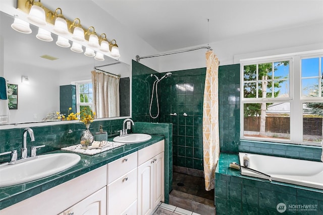 bathroom featuring tasteful backsplash, visible vents, tiled shower, and a sink