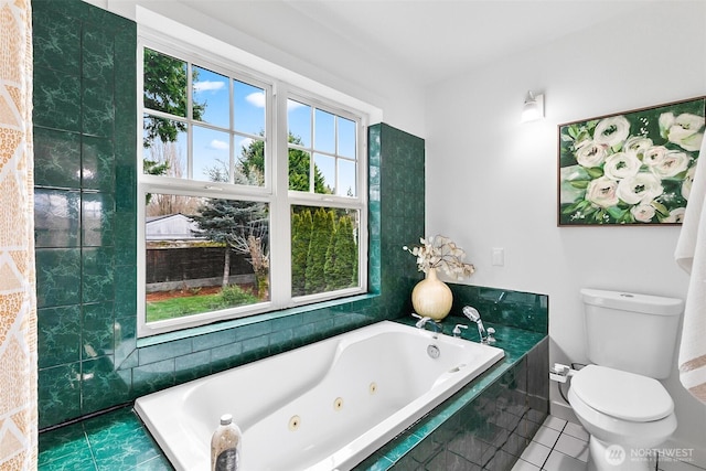 bathroom with tile patterned floors, a tub with jets, and toilet