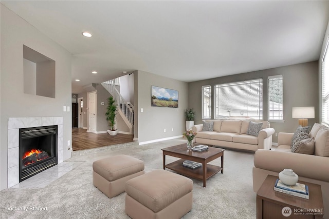 living room featuring recessed lighting, baseboards, stairway, and a tiled fireplace