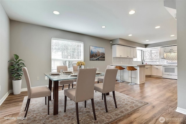 dining room with baseboards, recessed lighting, and light wood-style floors