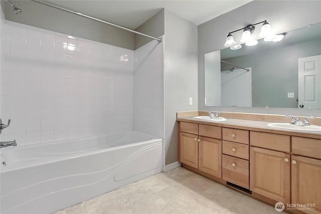 bathroom featuring shower / bathtub combination, double vanity, a sink, and tile patterned floors