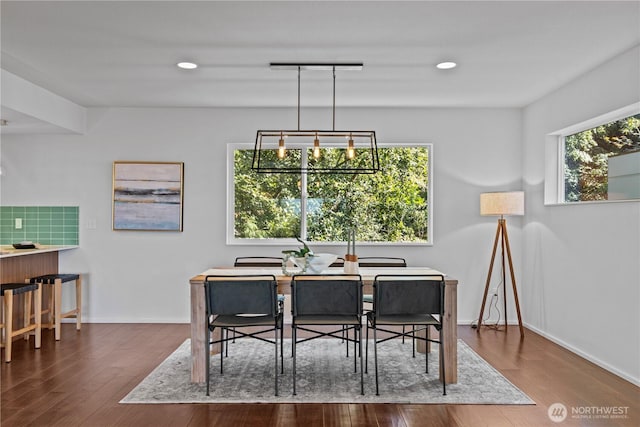 dining room featuring a healthy amount of sunlight, baseboards, wood finished floors, and recessed lighting