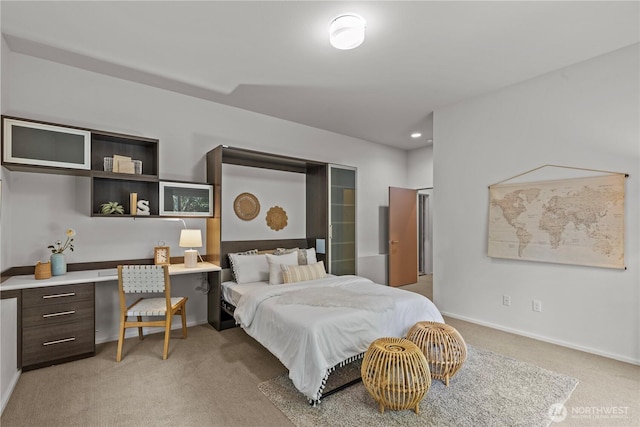 bedroom with light carpet, built in study area, and baseboards