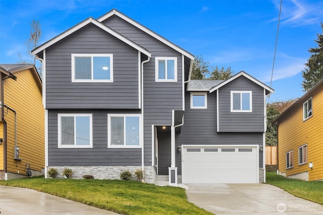 view of front facade featuring an attached garage, concrete driveway, and a front yard