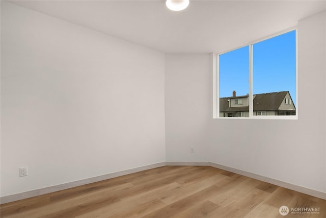 unfurnished room with light wood-style flooring and baseboards