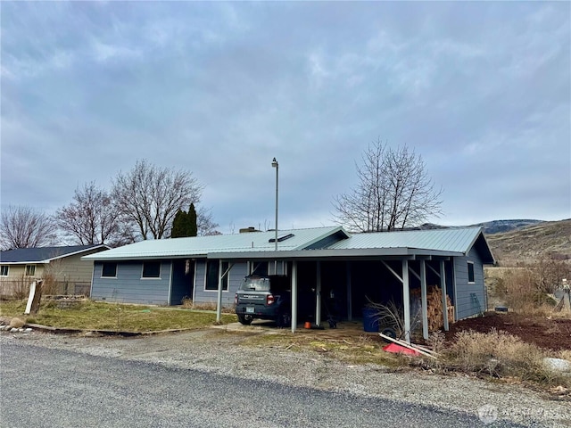 single story home featuring driveway, metal roof, and an attached carport