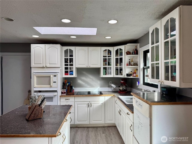 kitchen featuring open shelves, white appliances, glass insert cabinets, and white cabinets