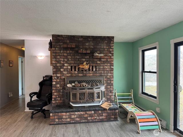 living area with a textured ceiling, wood finished floors, and baseboards