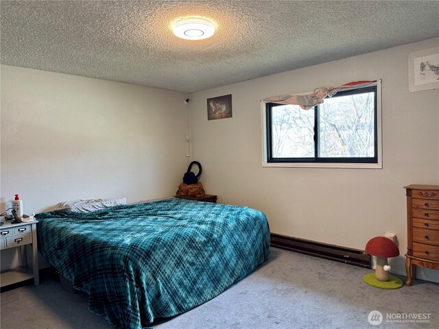 bedroom featuring light carpet, a textured ceiling, and baseboard heating