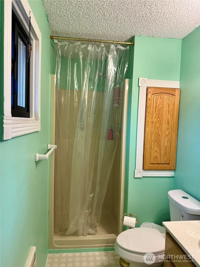 full bath featuring toilet, a stall shower, a textured ceiling, vanity, and tile patterned floors