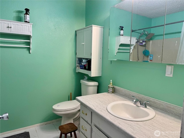 bathroom with toilet, a textured ceiling, vanity, baseboards, and walk in shower