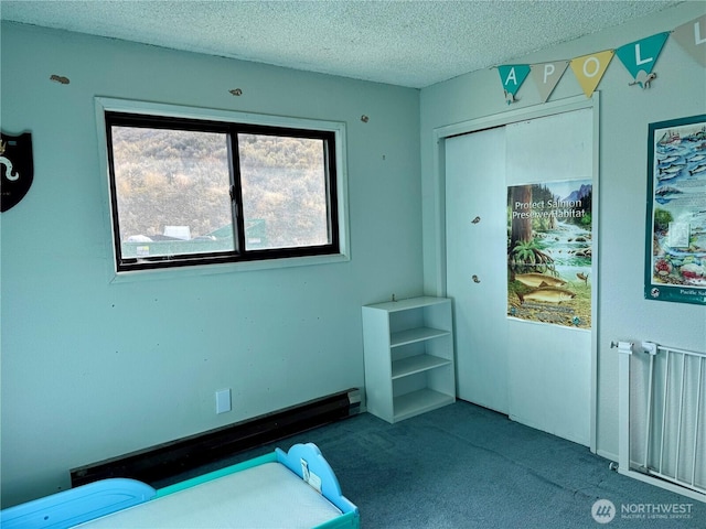 unfurnished bedroom with a textured ceiling, radiator heating unit, a closet, and carpet