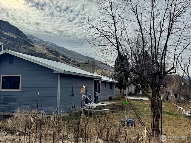 view of property exterior featuring metal roof and a mountain view