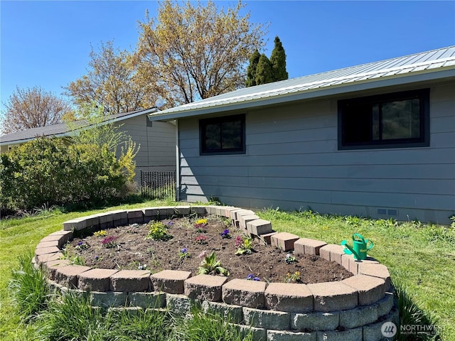 view of property exterior with metal roof and crawl space