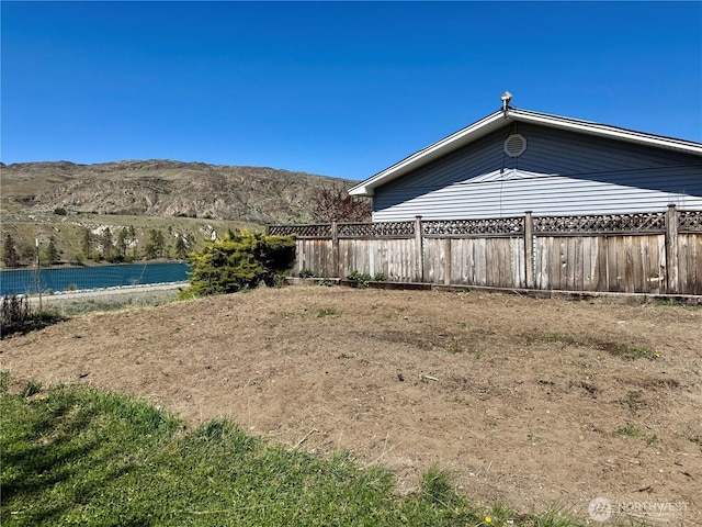 view of yard featuring a mountain view and fence