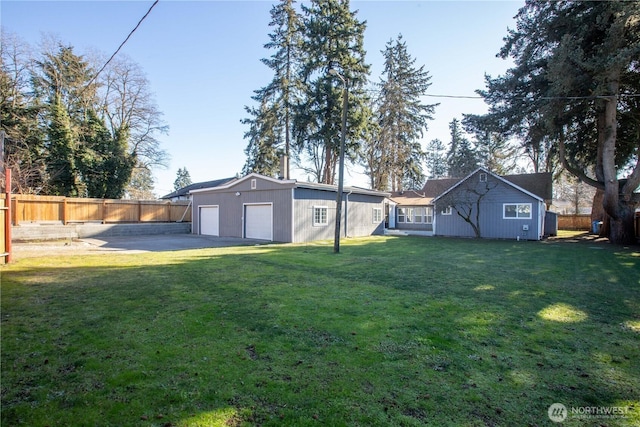 view of yard with a detached garage and fence