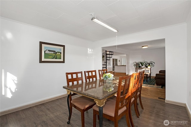 dining space with crown molding, dark wood finished floors, stairway, and baseboards