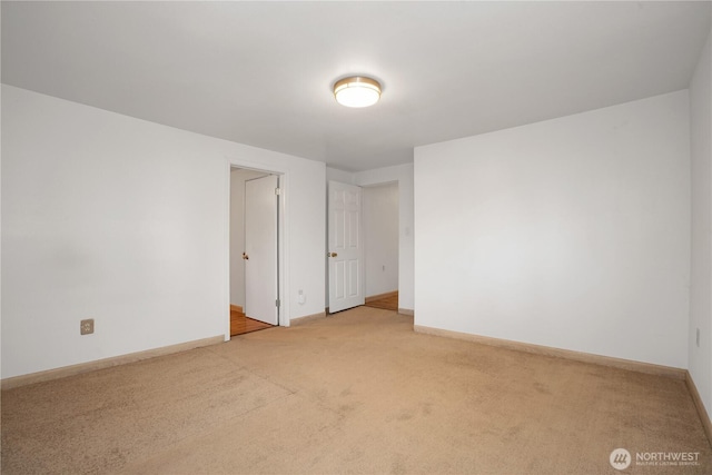 empty room featuring carpet flooring and baseboards